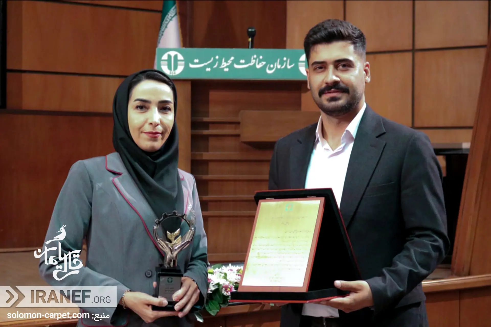 دو نفر از کارمنپدهای قالی سلیمان لوح رو دستشان گرفتند